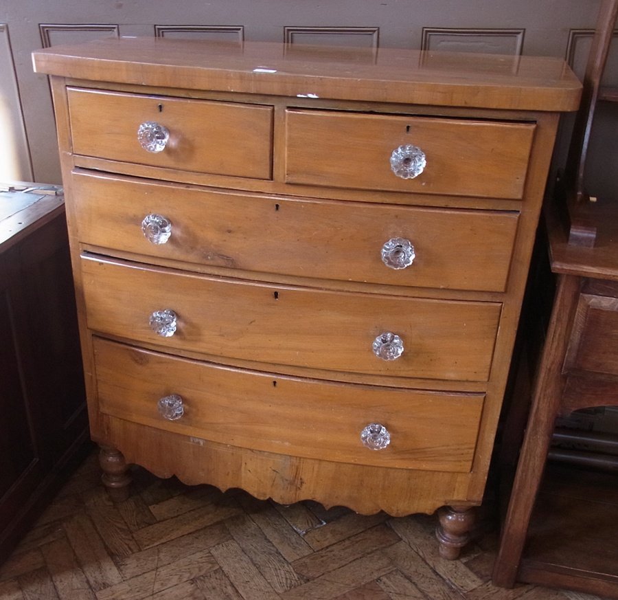 A satin birch bow-fronted chest of two short and three long drawers, with clear glass handles, on