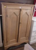 A pine wardrobe, pair of handles enclosing hanging space, on bracket feet, 99cm wide