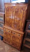 A modern figured walnut cabinet with panelled doors above enclosing shelving space, pull-out writing