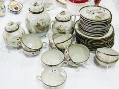 A Japanese porcelain part tea service, cream ground, black and gilt border decoration with figures