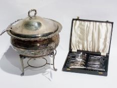 A silver plated lidded soup tureen with ladle, on stand, ice bucket, a boxed set of fish knives