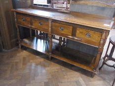 A reproduction oak dresser with raised back rail, moulded edge top with four frieze drawers below,