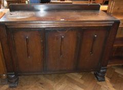 An early 20th century dark oak sideboard with three cupboards, with Art Deco style handles, on