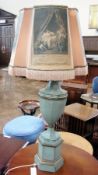 A pale green and gilt painted urn shaped tin table lamp, raised on a hexagonal shaped plinth with