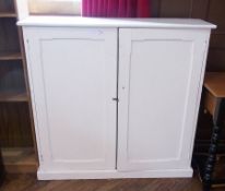 A white painted pine kitchen cupboard, pair panel doors enclosing shelving space, base 121cm wide