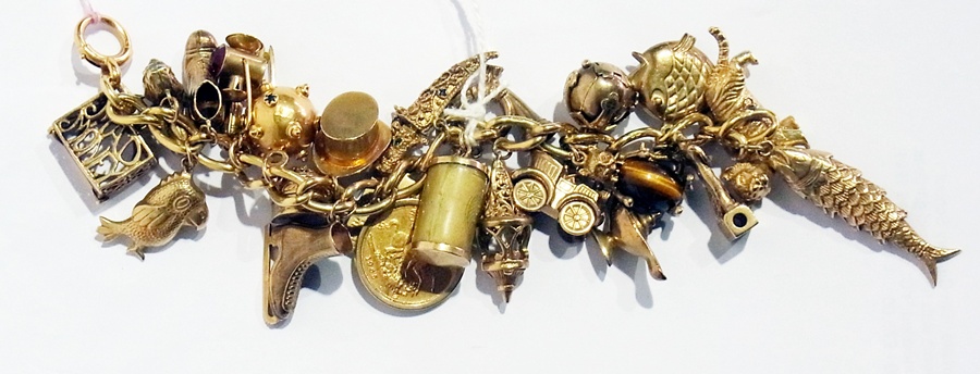 An 18ct gold bracelet set with a large collection of 9ct gold charms and a sovereign, 115g approx.