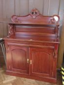 A Victorian mahogany chiffonier with a foliate carved back with shelf, pair of cushioned shaped