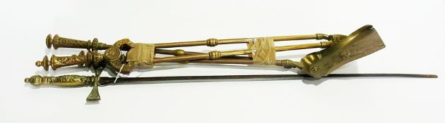 A brass hilted ceremonial sword with relief decoration and three brass fireside implements