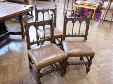 A set of eight Derbyshire style oak dining chairs with arcaded open backs, acorn finials, with split