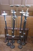 A quantity of church candle sconces, four brass in stand and six silver plated freestanding