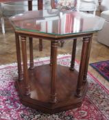 A mahogany octagonal table, with plate glass cover, on turned column supports to a platform base,