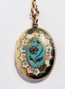 A gold-coloured metal and enamel oval locket with floral decoration and a 9ct gold oval link chain