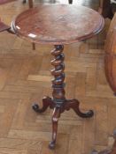 A Victorian mahogany tripod games table, circular top inlaid with chequerboard, on spirally turned