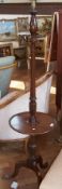 A mahogany standard lamp, turned column, with circular shelf raised on splayed tripod legs with