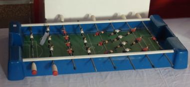 A blue plastic table football set with wooden painted pitch