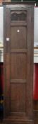 Oak hanging narrow cupboard having framed panelled sides and door, stylised foliate arch carved to