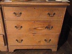 Pine chest of three long drawers with brass swan-neck handles, on bracket style feet, 84cm wide