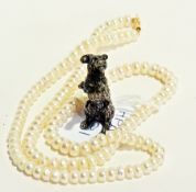 A cultured pearl necklace together with a silvered model of a dog (2)