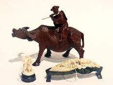 Chinese carved hardwood figure of boy playing flute on the back of an ox, together with two other