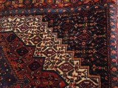 Persian style wool rug in red, blue and cream with central medallion and multi-borders, 162cm x