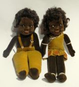 A soft velvet bodied black girl and boy doll with brown hair, brown fixed glass eyes, moulded