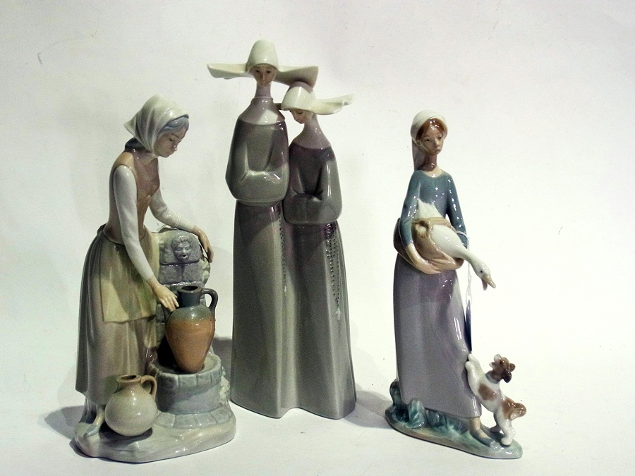 Lladro figure of two nuns, another of goose girl with puppy and Nao figure of girl at well