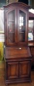 Reproduction polished wood library bookcase having arched top, glazed doors to the top section,