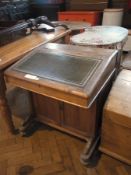 A pine bureau with leather inset top, hinged lid enclosing drawers, with panelled cupboard below, on