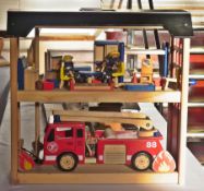 A painted wood fire station complete with furnishings and figures together with a fire engine