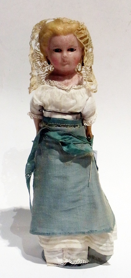 A wax over papier mache shoulderhead doll with moulded hair, pierced ears, fixed glass eyes and
