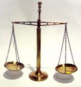 A pair of brass balance scales raised on a reeded column with brass pans on a circular foot