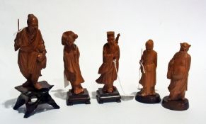 Five oriental carved hardwood figures of sages and a fisherman, woman holding lily, etc.