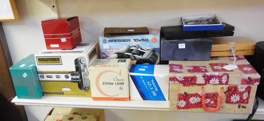 A pair of Bresser 10x50 binoculars in box, an Olympus OM40 camera in box, Sigma 24mm lens in box,