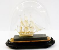 Miniature carved ivory triple masted sailing galleon, on stained wooden stand, oval plinth under