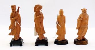 A pair of oriental carved hardwood figures of sages and lady holding lily leaf on hardwood bases,