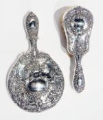 A silver sterling-backed hand mirror together with a matching hairbrush, of foliate scrollwork