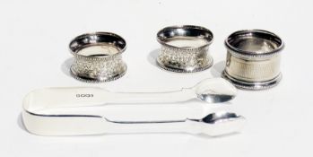 A pair of  Victorian silver fiddle pattern sugar tongs, together with three various silver napkin