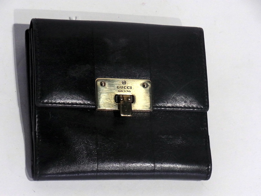 Gucci black leather wallet with metal clasp, engraved brass mounts marked "Gucci" and embossed
