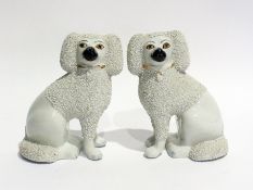 A pair of Staffordshire-style pottery chip-coated model poodles, 21cm high