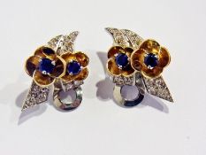 A pair of sapphire and diamond clip earrings, each with double gold flowerhead with blue sapphire