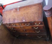 An antique oak bureau with fall-front enclosing an arrangement of pigeonholes and drawers, four