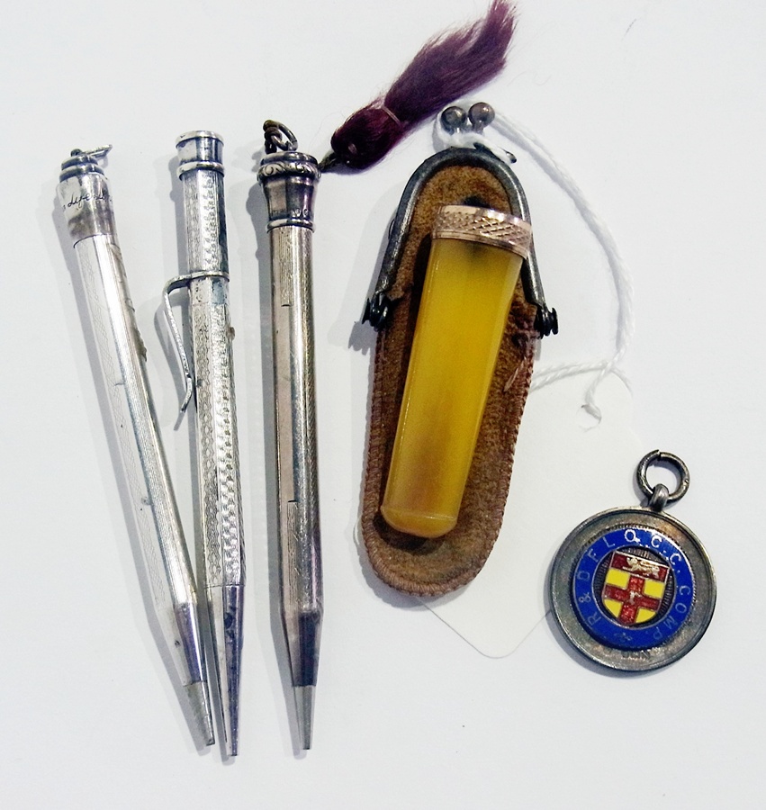 Three propelling pencils, a cheroot holder together with a silver and enamel sports medal