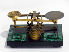 A pair of brass scales and weights on a slate and malachite stand of stylised Greek key design, on