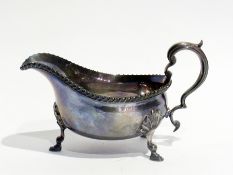 A George V silver sauce boat, with gadrooned border, scroll handle, raised on pad feet, London 1917,