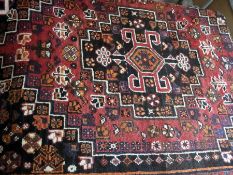 Persian wool rug with a central medallion, on dark ground with red and ivory border