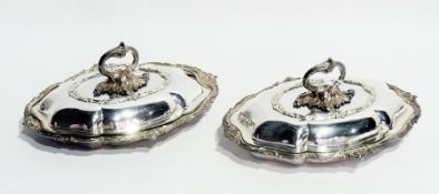 A pair of silver plate entree dishes with covers, with foliate wavy edge borders
