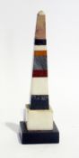A polished stone obelisk of various different coloured layers, 18cm high