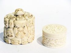 Japanese carved ivory oval lidded pot of multiple mask head design, 6cm high, together with a