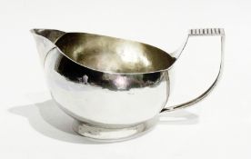 A modernist silver cream jug, circular and bulbous, with D-shaped and ribbed handle, circular