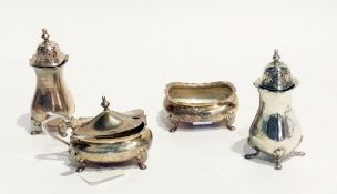A George V silver condiment set comprising a pair of pepperpots, an open salt and a lidded mustard